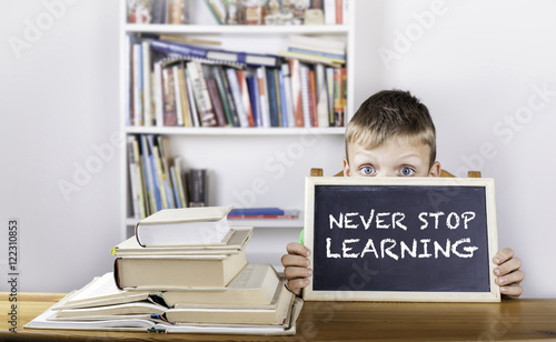 Never Stop Learning. Boy holding blackboard