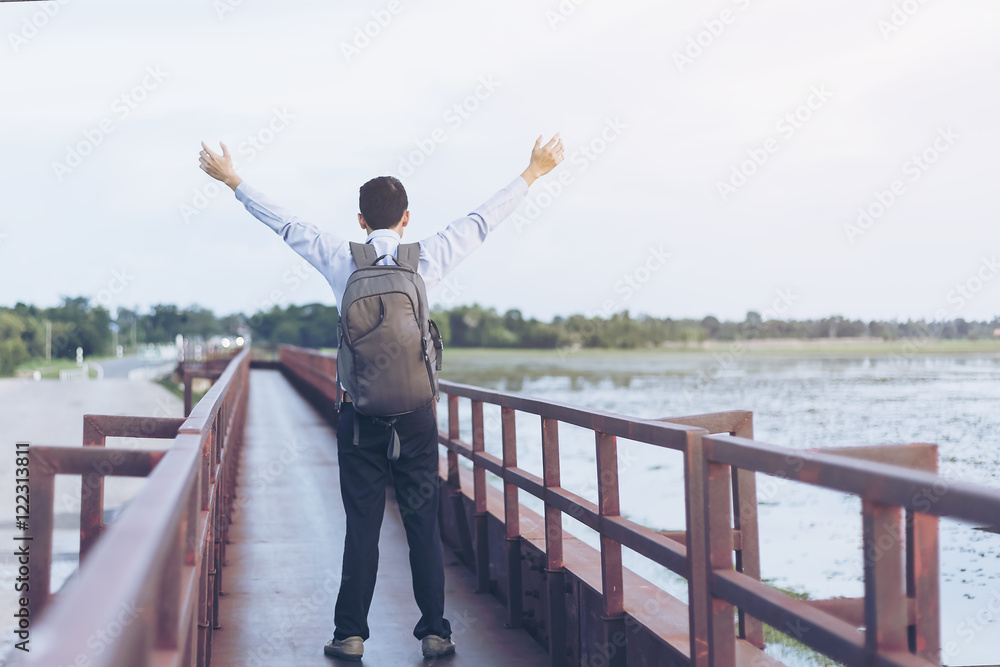 Rear view portrait of young man backpack standing on the bridge Rear view portrait of young man backpack standing on the bridge