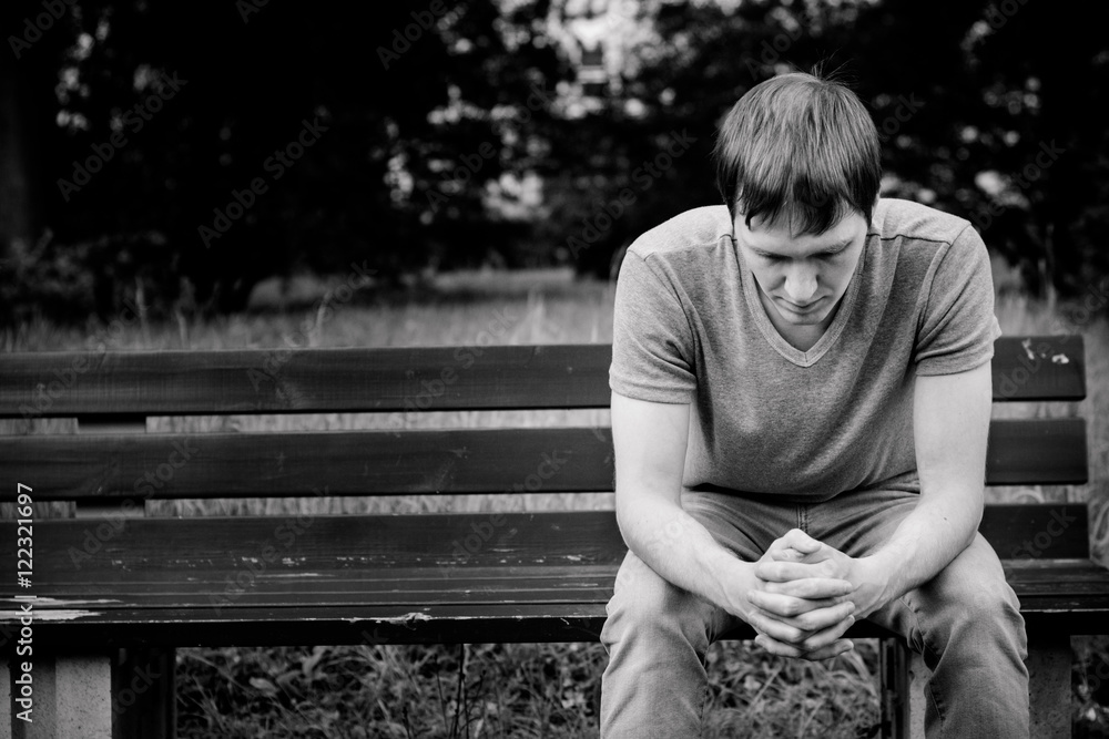 A man sits on a bench. He is sad and pensive.
 - obrazy, fototapety, plakaty 