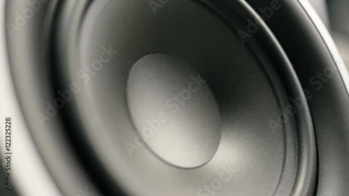 A close up of large subwoofer moving.