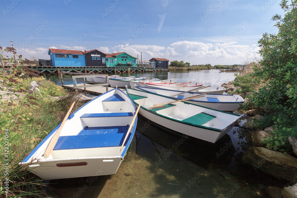 Naklejka premium petites barques colorés au port des salines sur l'ile d'oléron avec ses cabanes en bois