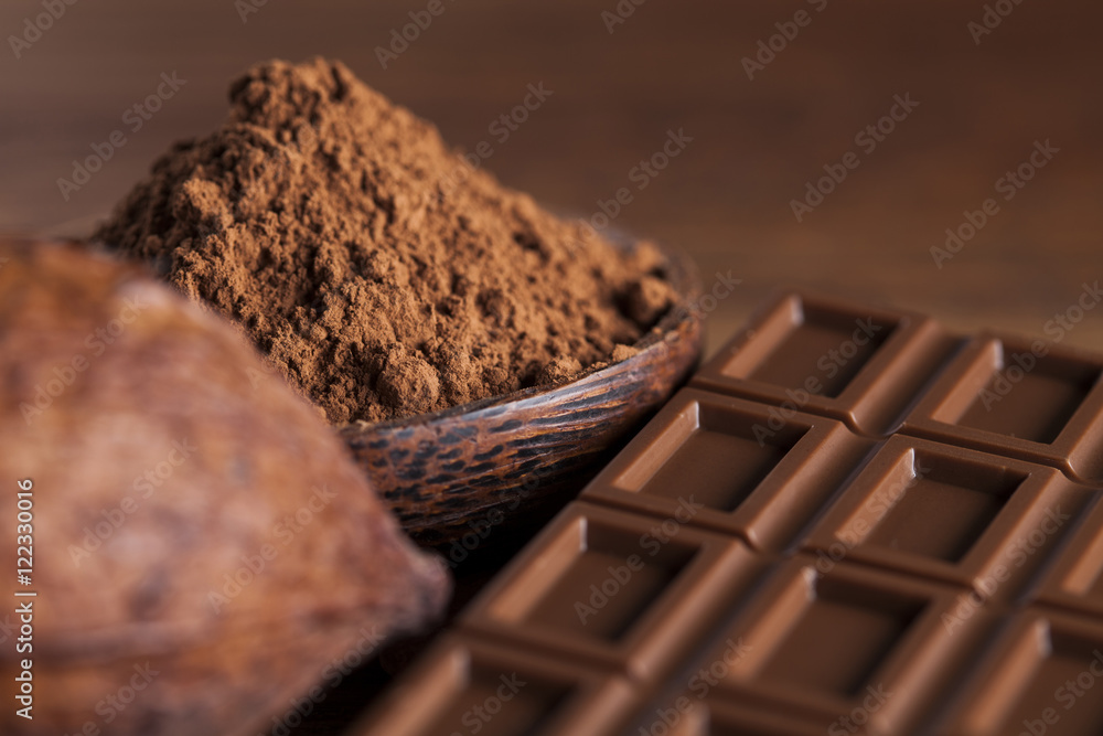 Chocolate bar, candy sweet, cacao beans and powder on wooden bac Chocolate bar, candy sweet, cacao beans and powder on wooden bac