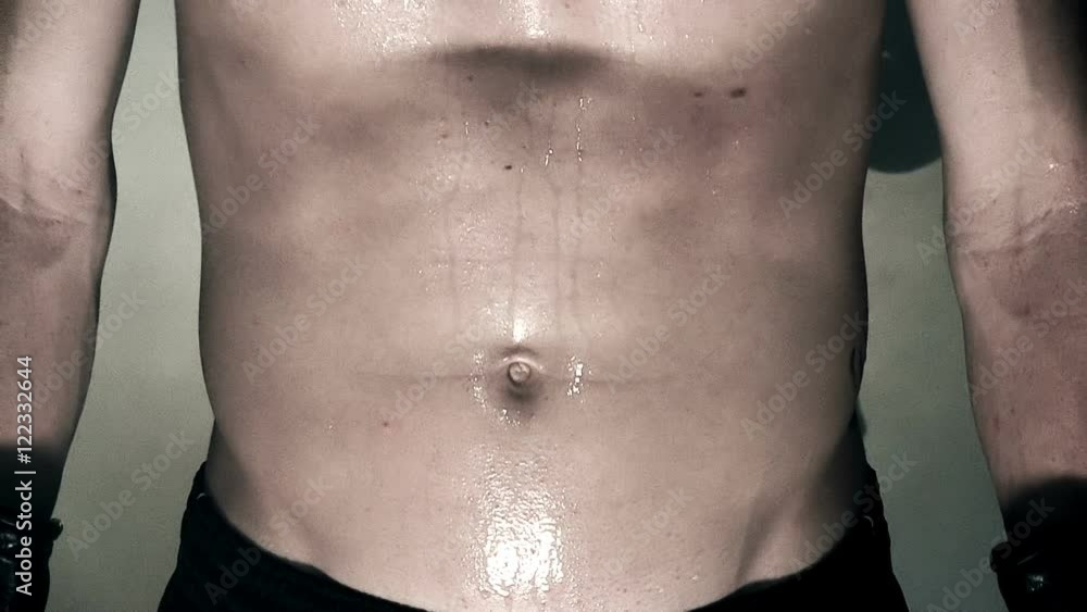 Extreme close up of a fit young man's stomach during a workout. Extreme close up of a fit young man's stomach during a workout.