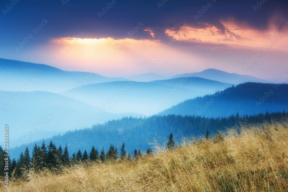View of colorful sunrise in autumn mountains.