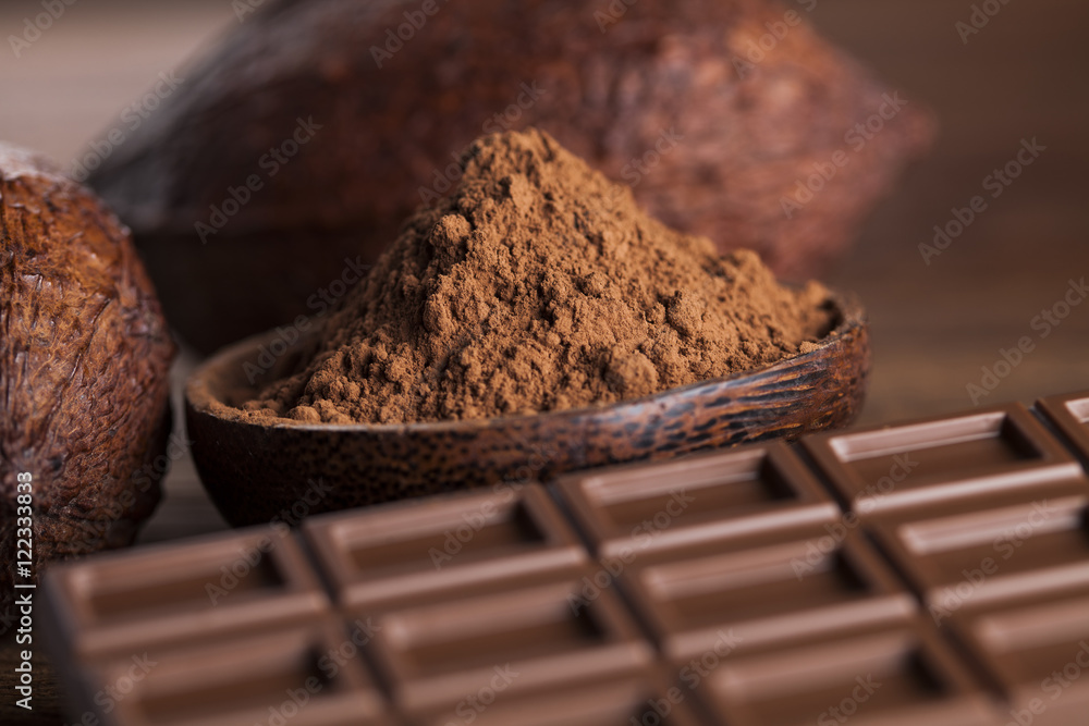 Chocolate bar, candy sweet, cacao beans and powder on wooden bac Chocolate bar, candy sweet, cacao beans and powder on wooden bac