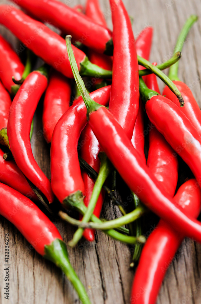 multitude of red chili peppers on wooden table, closeup view