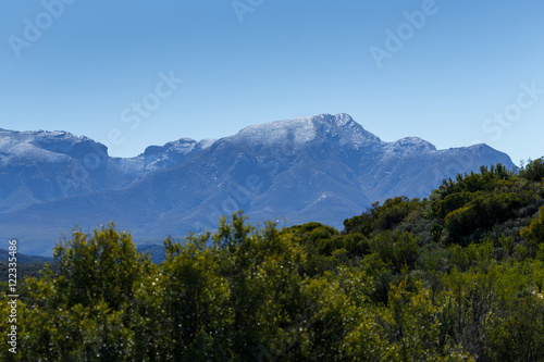 Green Landscape with silver snow filled mountain range in De Rus