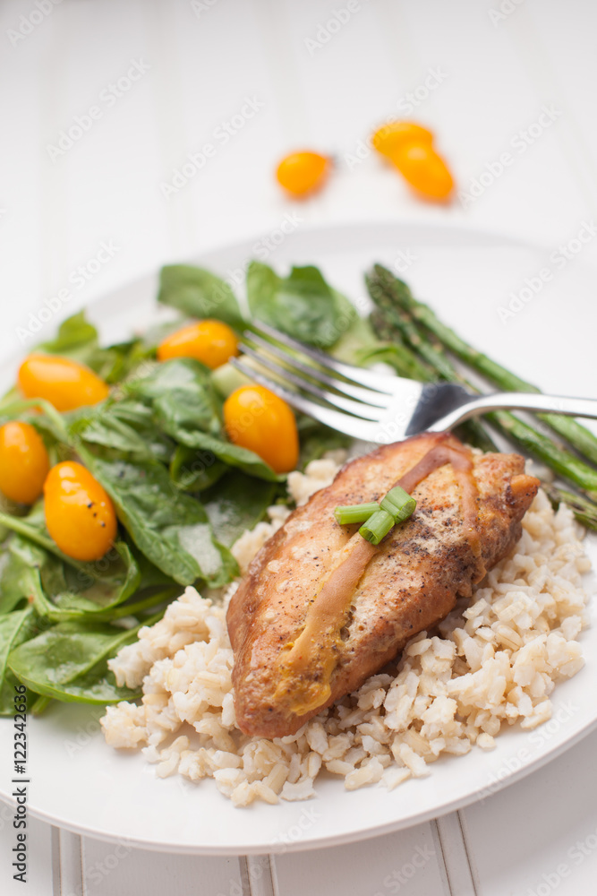 Dinner plate of lemon pepper mustard chicken with brown rice, Italian garden salad, and asparagus cooked in avocado oil on white Dinner plate of lemon pepper mustard chicken with brown rice, Italian garden salad, and asparagus cooked in avocado oil on white