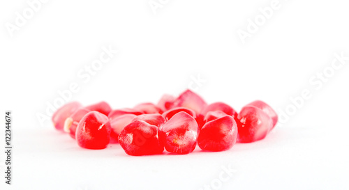 Ripe pomegranate seeds on a white background.