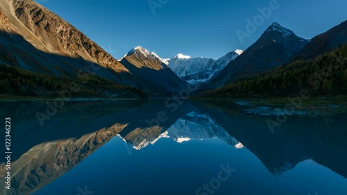 Time Lapse. The Mountain Belukha in the reflection Akkem lake at sunset. Altai Mountains, Russia.