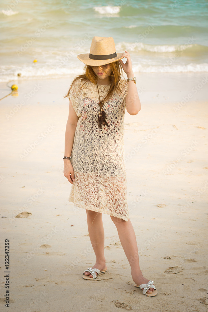 Fashion portrait of asian beautiful girl  with hippie outfit and hat outdoors at sunset on the sea. Soft warm color tone. Boho lifestyle. Bohemian Style.