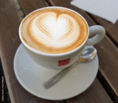 Delicious cappuccino coffee cup with froth heart design