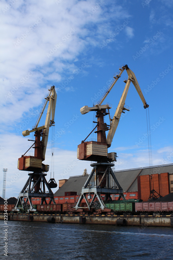Two yellow cargo container cranes in harbor