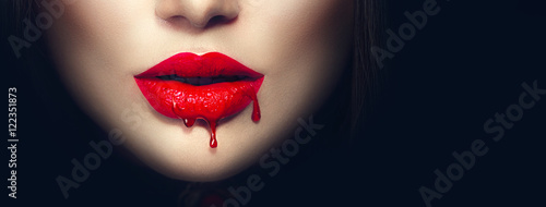 Fotografia Sexy vampire red lips with dripping blood closeup isolated on black background