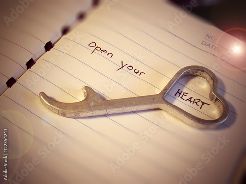 Heart shape bottle opener on top of a notepad with caption 