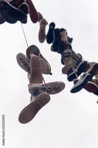 Many shoes hanging across road on a string in Flensburg