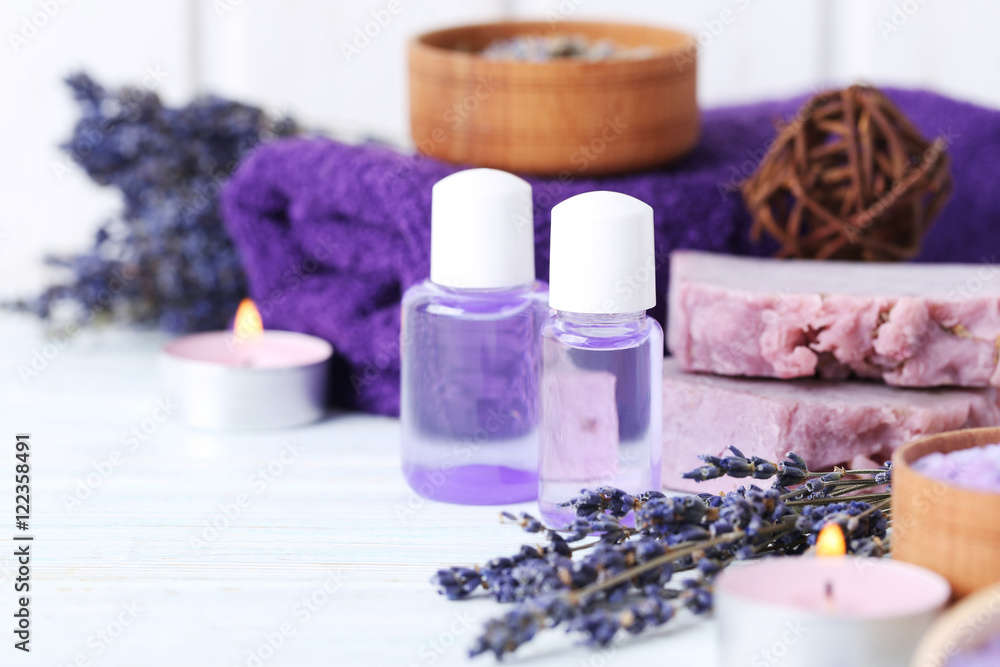 Lavender oil with soap and flowers on white wooden table Lavender oil with soap and flowers on white wooden table