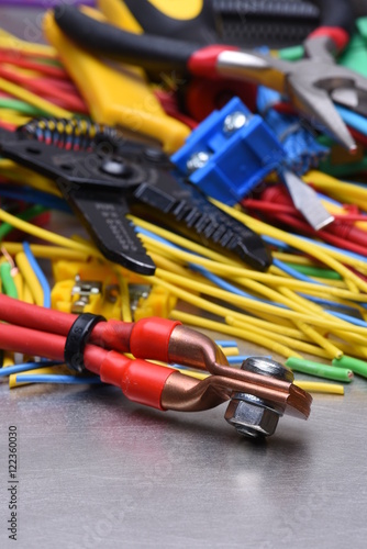 Tools for electrician and cables on grey metal surface