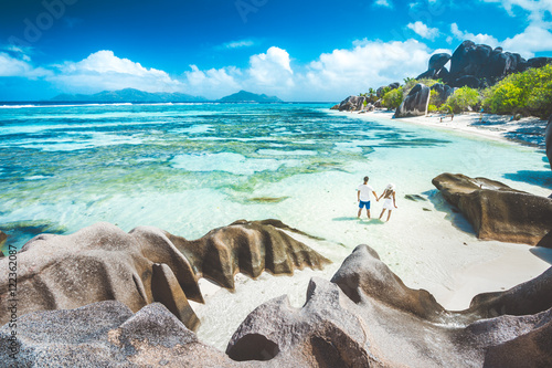 A young couple standing in shallow water on La Digue island, Sey