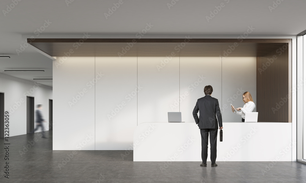 Rear view of man talking with receptionist Rear view of man talking with receptionist