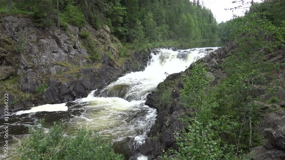 Panorama Waterfall on the rocks in wild nature. Rapid and wild streams of water falls up close. Northern rivers on the rocky ledges. Panorama Waterfall on the rocks in wild nature. Rapid and wild streams of water falls up close. Northern rivers on the rocky ledges.