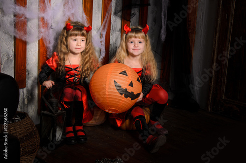 two halloween devils girls with pumpkins