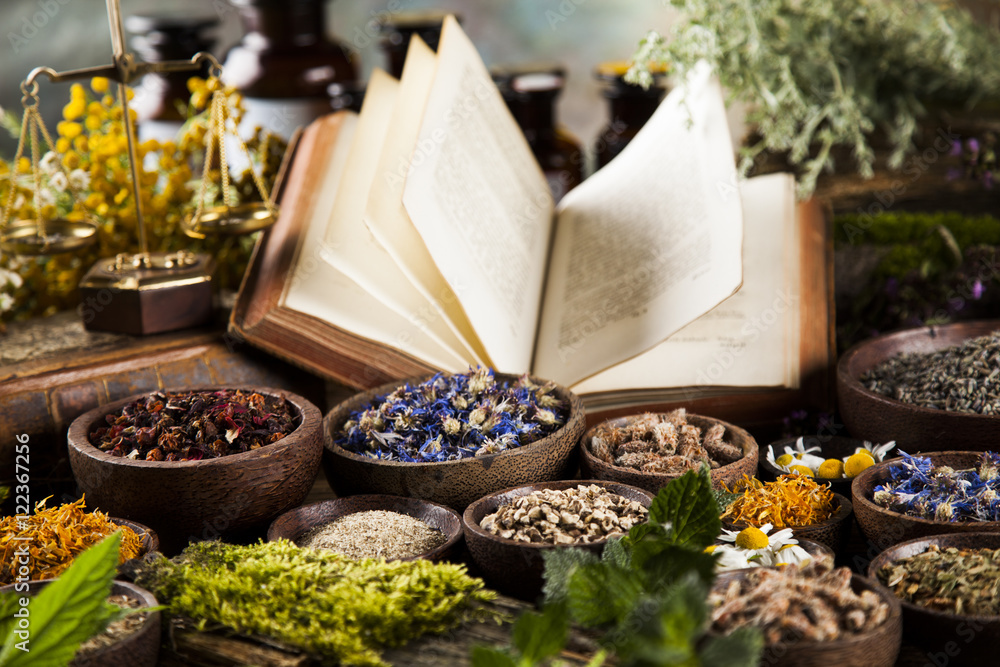 Book and Herbal medicine on wooden table background - obrazy, fototapety, plakaty 