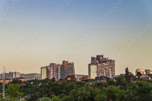 Neighborhood of low-rise residential buildings with multi-storey buildings on a steep slope. Evening skyline. City Belgorod, Russia.