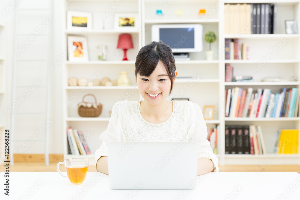 attractive asian woman using laptop computer
in the living room attractive asian woman using laptop computer
in the living room