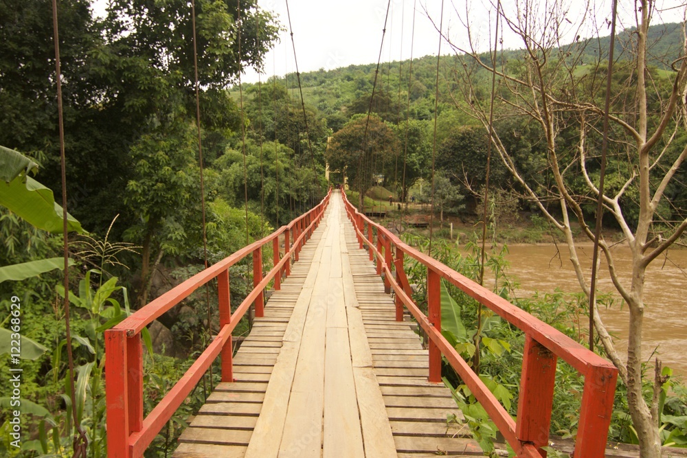 Wooden suspension bridge across the river