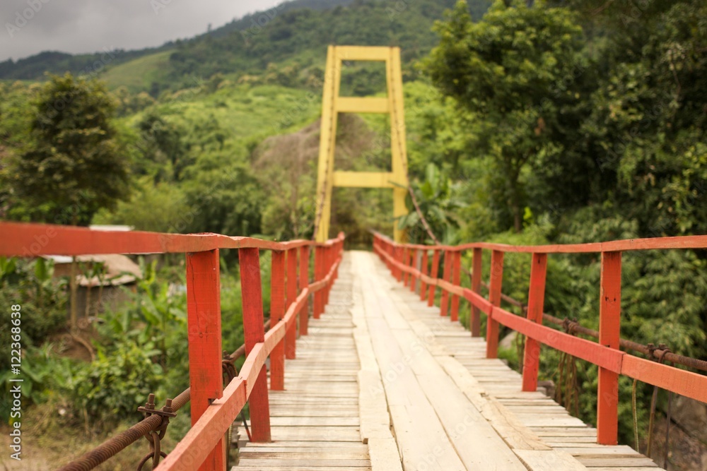 Wooden suspension bridge across the river Wooden suspension bridge across the river