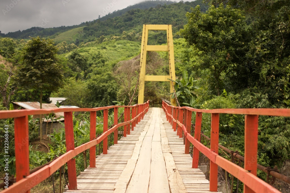 Wooden suspension bridge across the river Wooden suspension bridge across the river