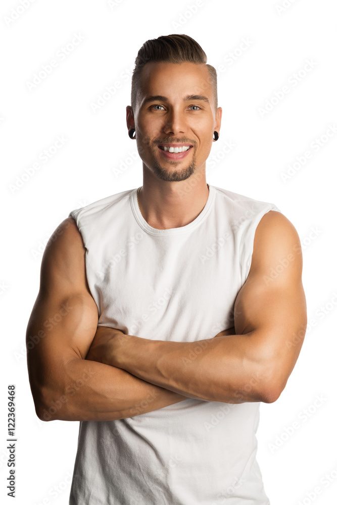 Well trained and attractive man wearing a white tank top standing against a white background with his arms crossed. Well trained and attractive man wearing a white tank top standing against a white background with his arms crossed.