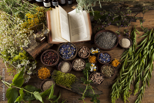 Photo Herbal medicine and book on wooden table background