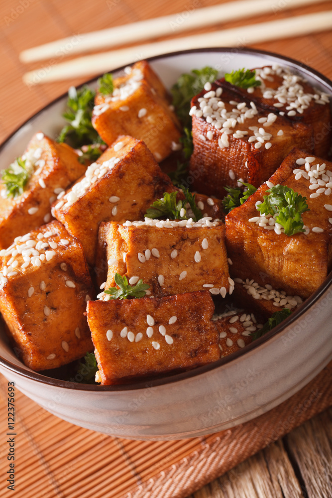 Vegetarian tofu fried with sesame and herbs in a bowl close-up. vertical
Vegetarian tofu fried with sesame and herbs in a bowl close-up. vertical