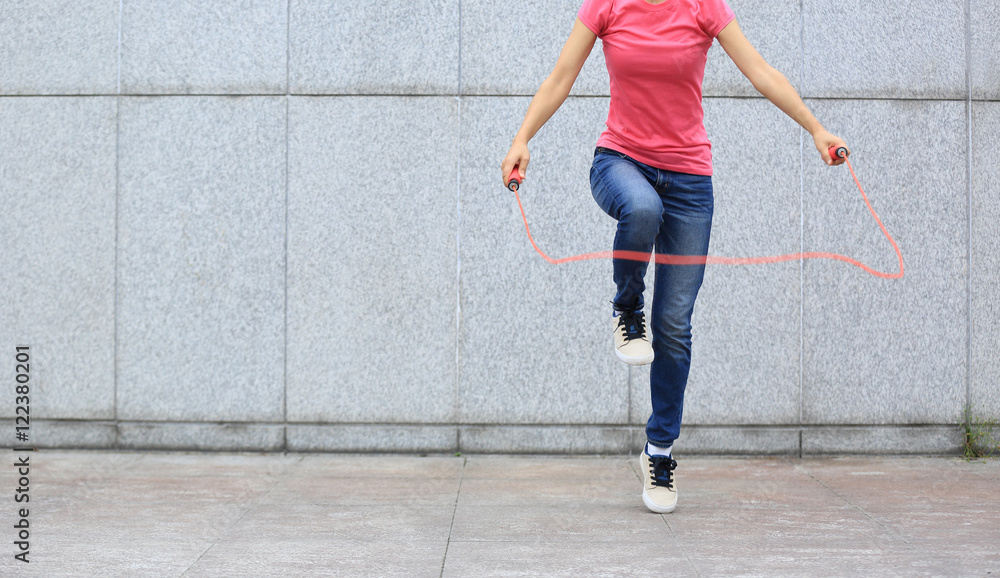 young fitness woman jumping rope outdoor