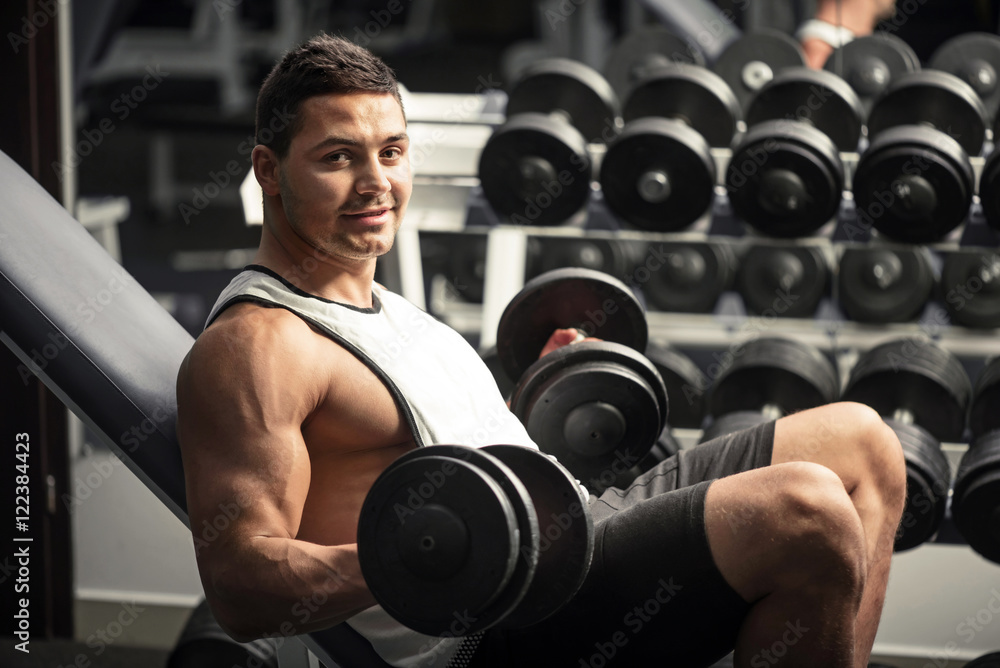 Pleasant athletic man lifting dumbbells Pleasant athletic man lifting dumbbells
