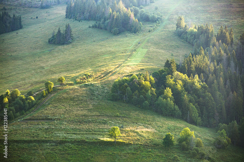 Mountain landscape and meadow illuminated by the sun