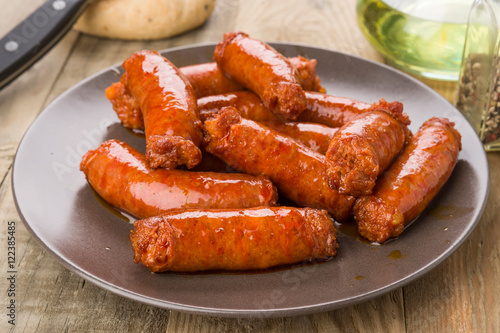 grilled sausage on brown porcelain dish on wood