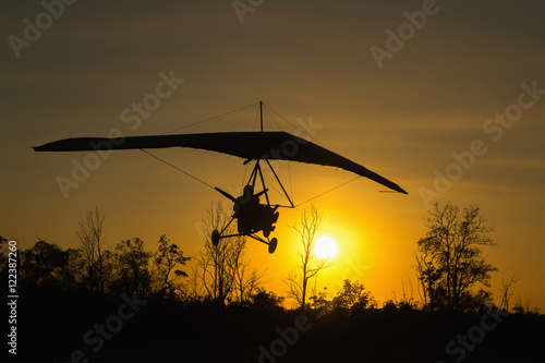 Фотография Man on hang glider land at sunset