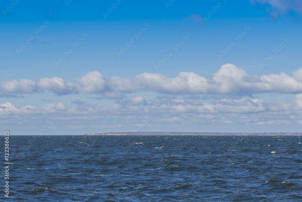 blue sea and sky. The ship sails past the coast with the settlement and now. blue sea and sky. The ship sails past the coast with the settlement and now.