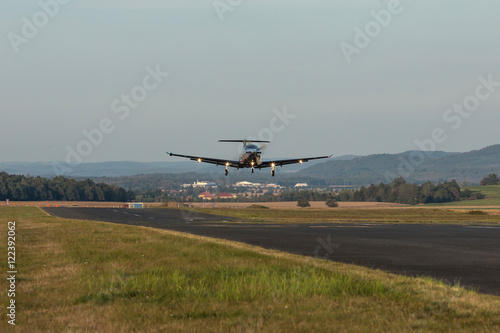 Single-engine turboprop aircraft departing from a small airport.