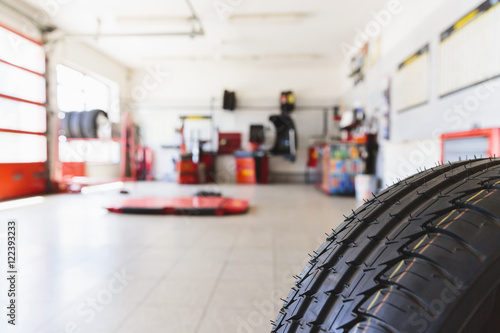 Defocused view into the auto repair shop with a tire in front