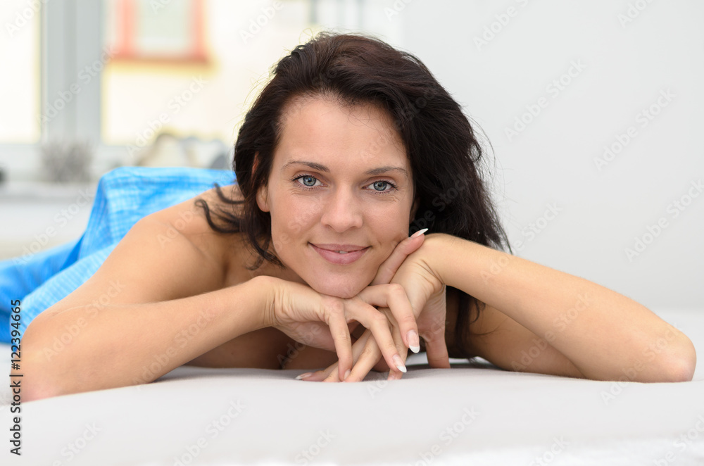 Attractive friendly woman relaxing on her bed Attractive friendly woman relaxing on her bed