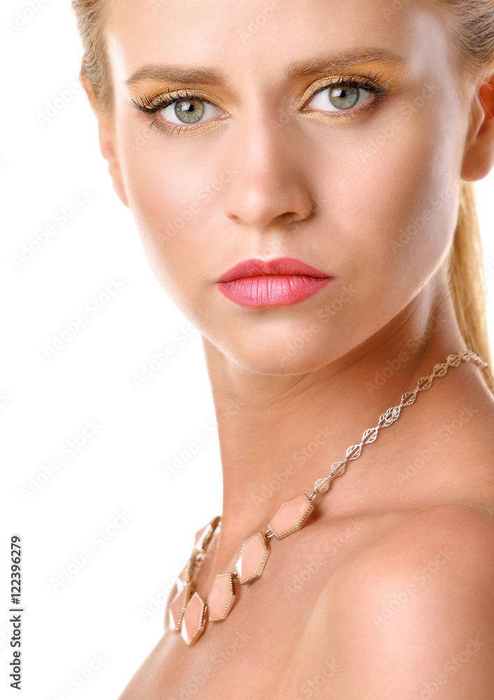 Portrait of young woman with beautiful necklace on white background