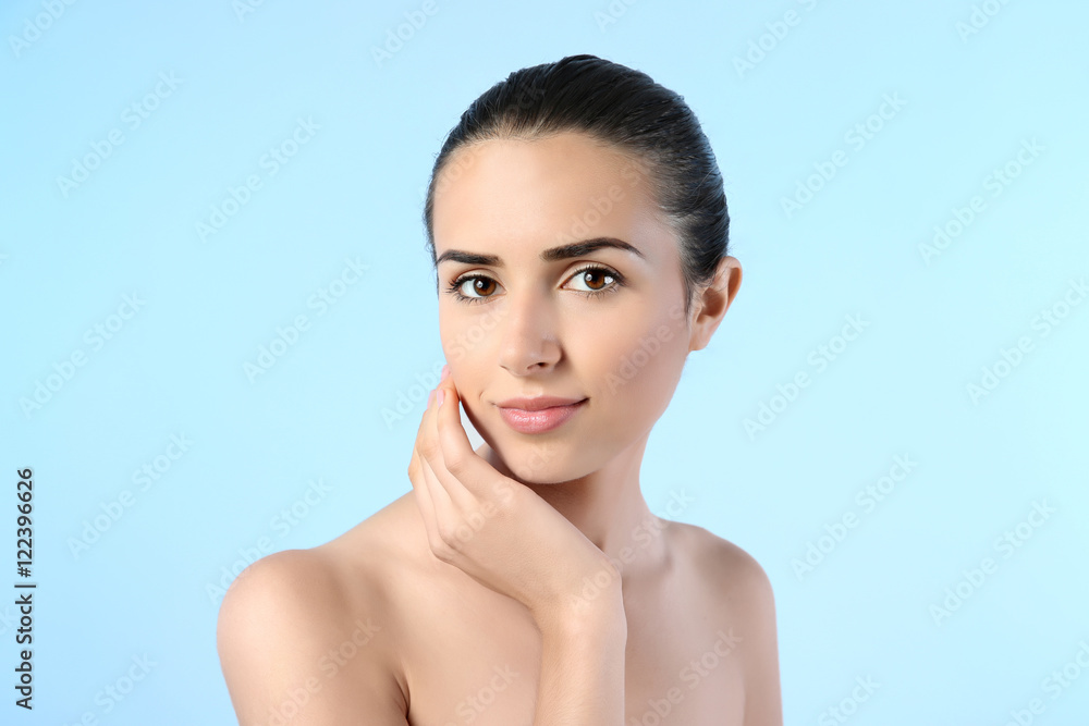Attractive young woman with natural makeup on blue background