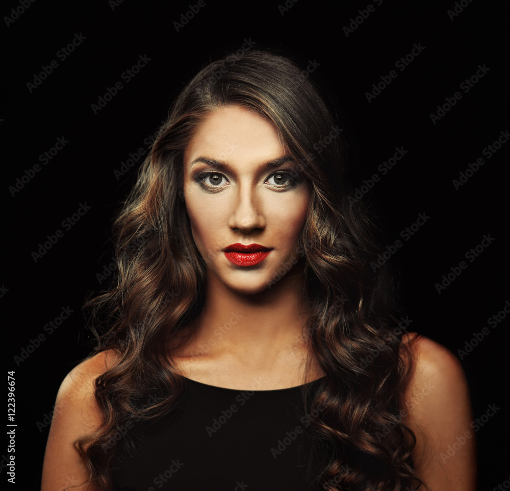 Fototapeta premium Beautiful young woman with make up and long wavy hair on black background