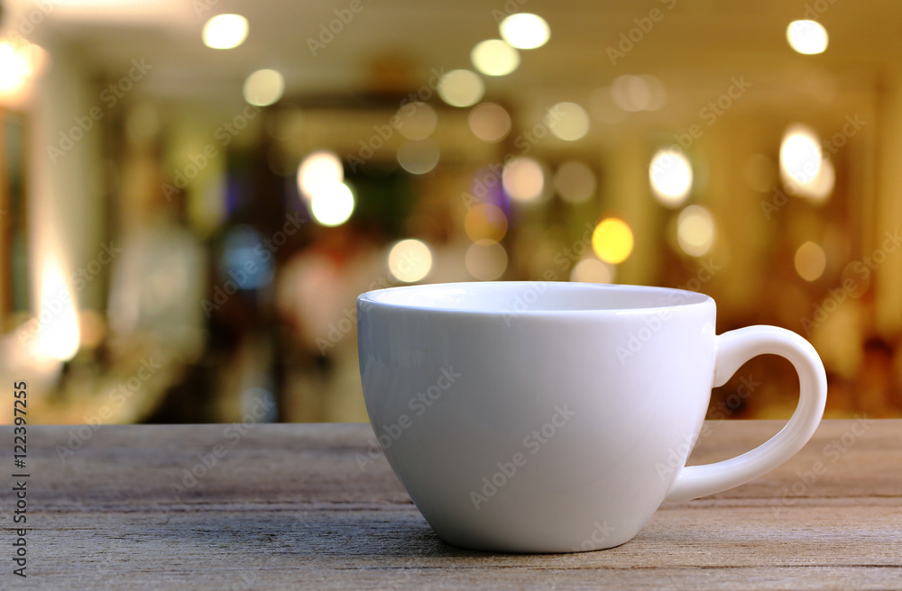 White Coffee cup on wooden table in coffee shop blur background. White Coffee cup on wooden table in coffee shop blur background.