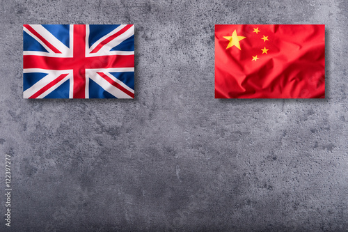 Flags of the united kingdom and china on concrete background. photo