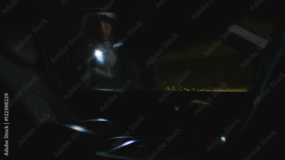 Abstract angle of thief looking into a locked car for valuables at night Abstract angle of thief looking into a locked car for valuables at night